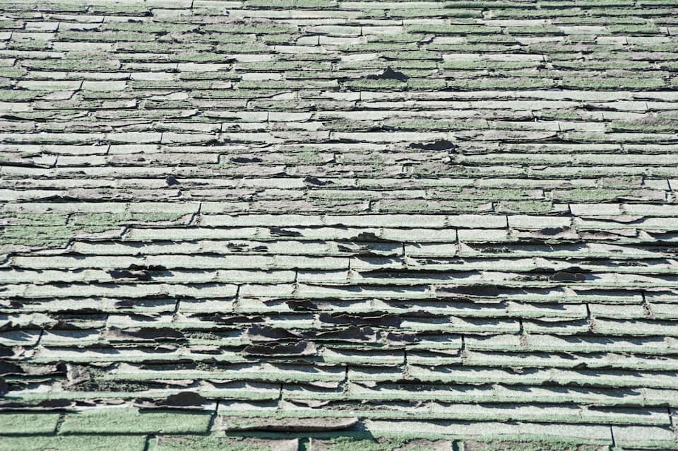 Close-up of aging asphalt shingles showing wear patterns that often lead to repair calls