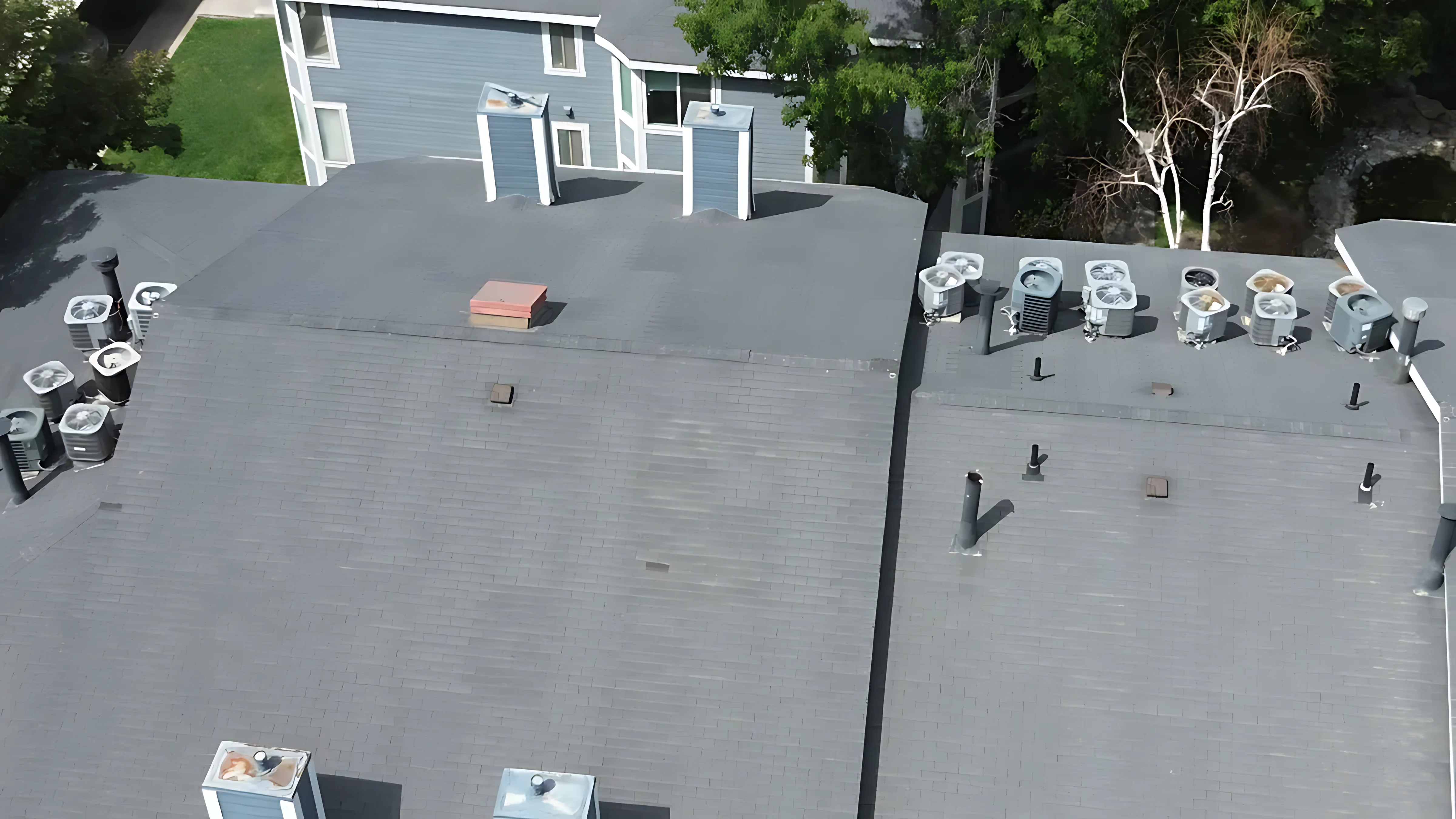 A missing roof cricket leading to water pooling and debris buildup behind a large chimney