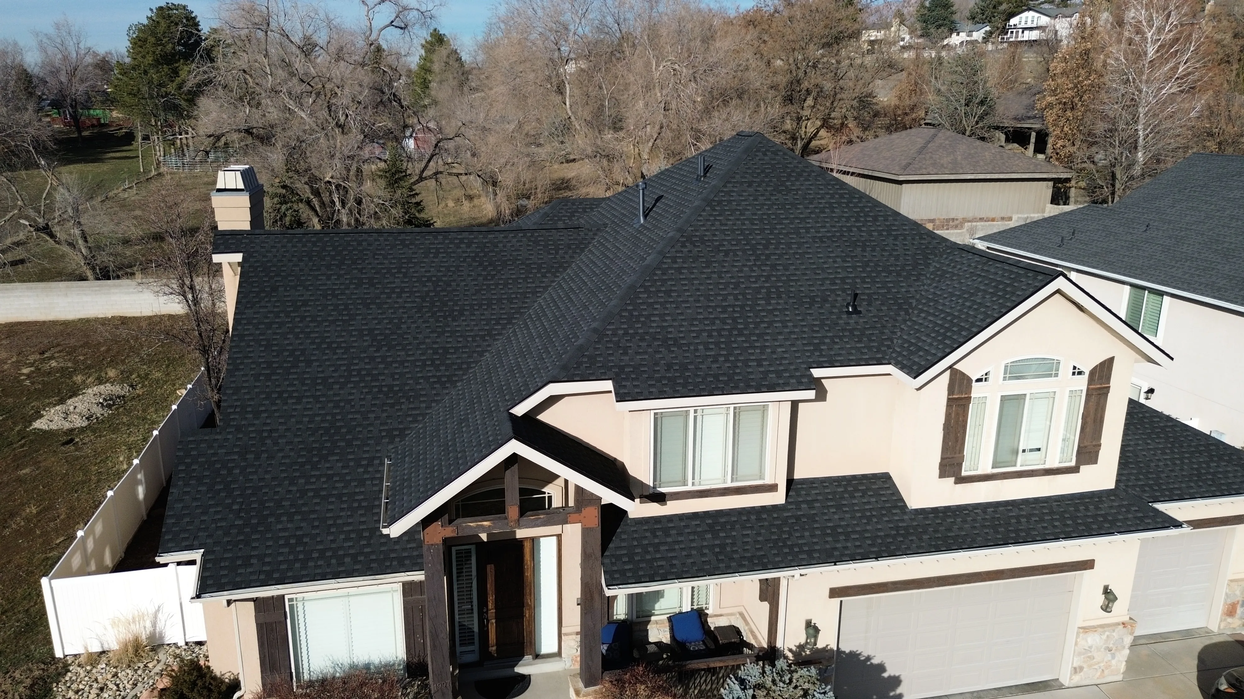A professional roofing crew working on a Salt Lake City home with the Wasatch mountains in the background